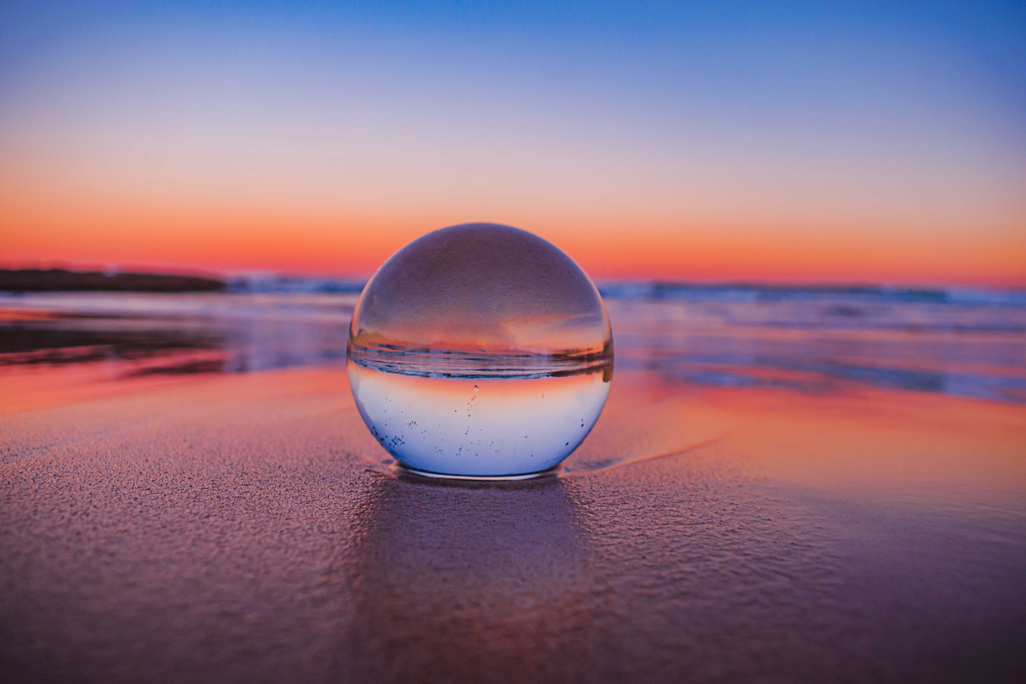 clear glass ball on sand
